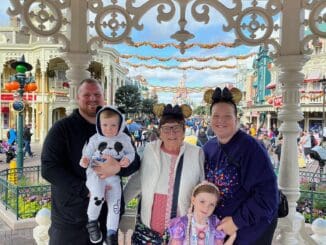 family photo in the gazebo with sleeping beauty castle in background